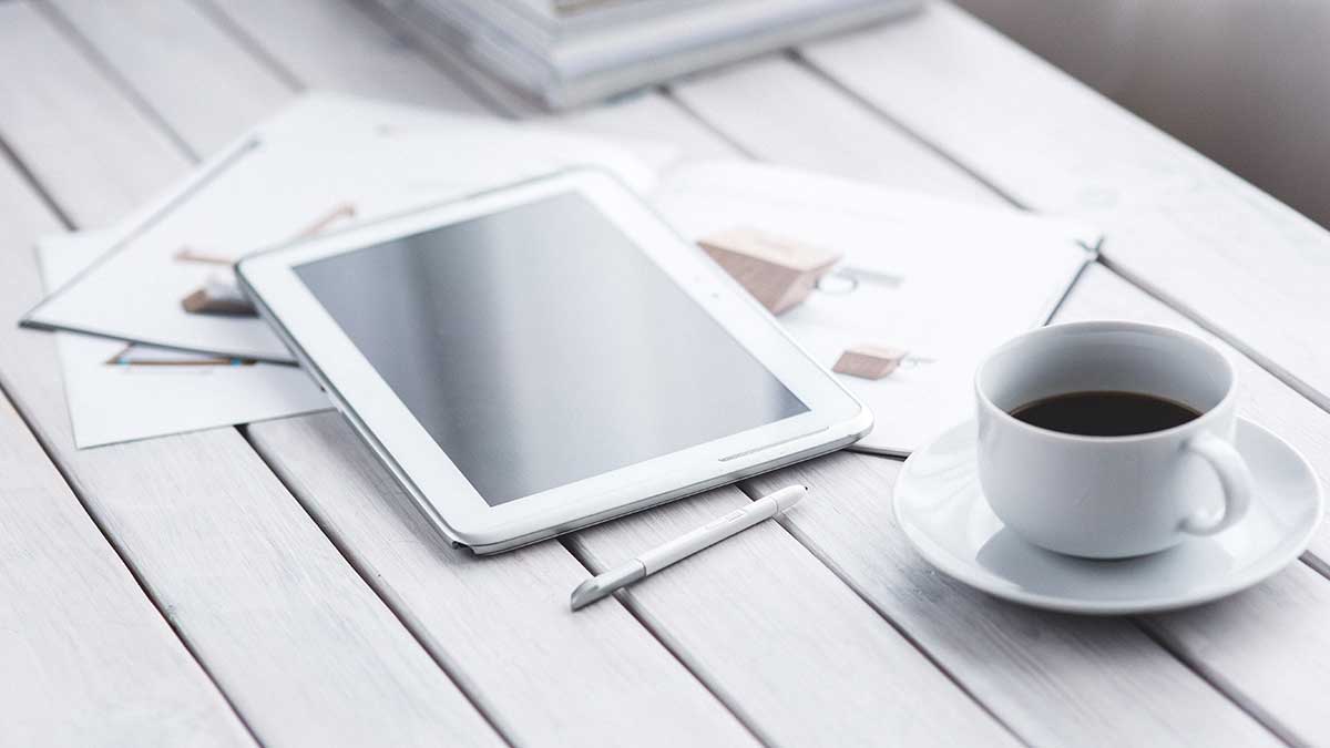 A tablet and a cup of coffee